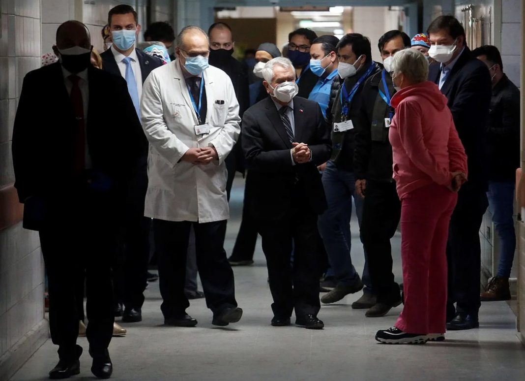 El nuevo ministro de Salud de Chile, Enrique Paris (centro), visita este martes un hospital en Santiago